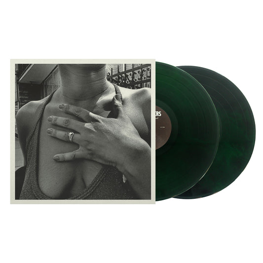 image of two neon green and black vinyls on the right coming out of the sleeve of the menzingers album on the impossible past on a white background. the album cover is a black and white photo of a woman with her hand over her chest